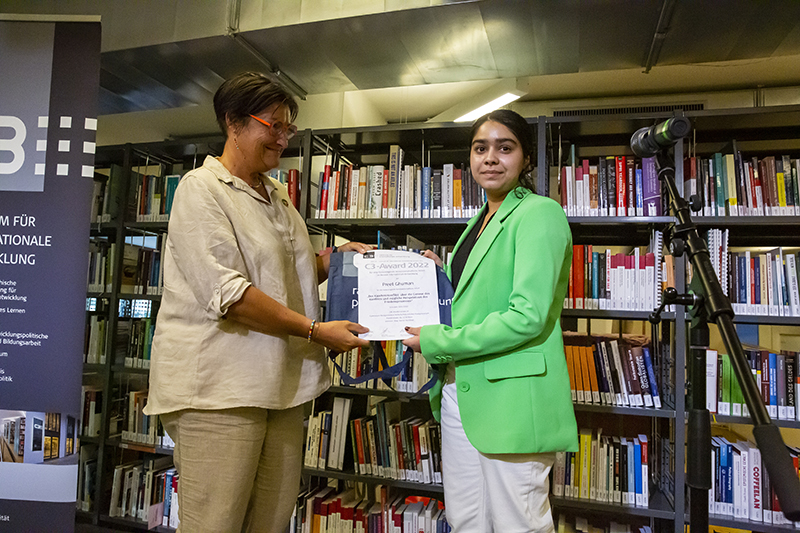 Zwei Frauen auf einer Bühne bei der Übergabe einer Urkunde