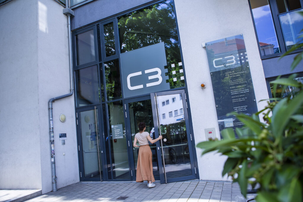 Eingang ins C3, eine junge Frau öffnet die Türe und geht hinein