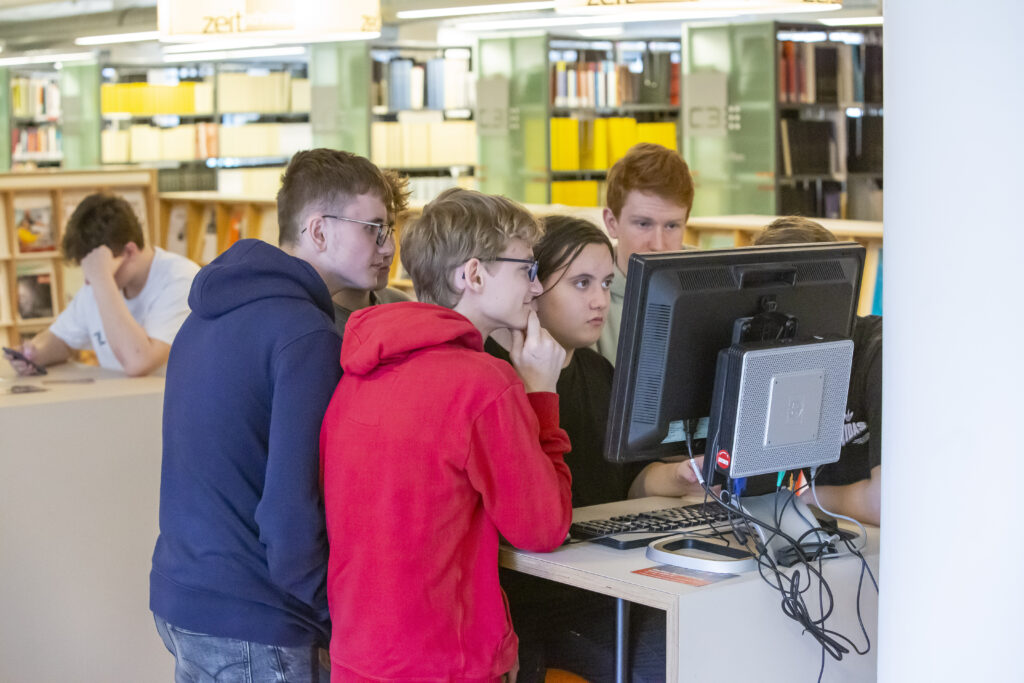 Jugendliche in der Bibliothek vor PC