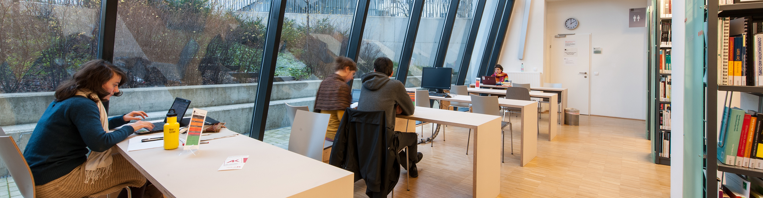 Nutzer_innen sitzen auf Arbeitsplätzen in der C3-Bibliothek