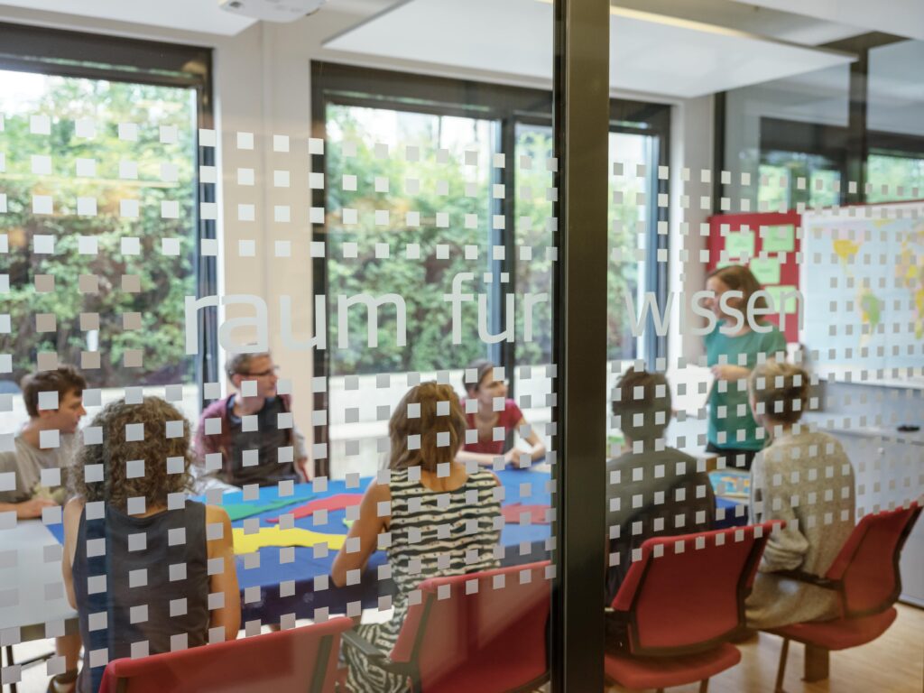 zu sehen ist eine Gruppe von Personen, die im Seminarraum der C3 an einer Fortbildung teilnimmt.